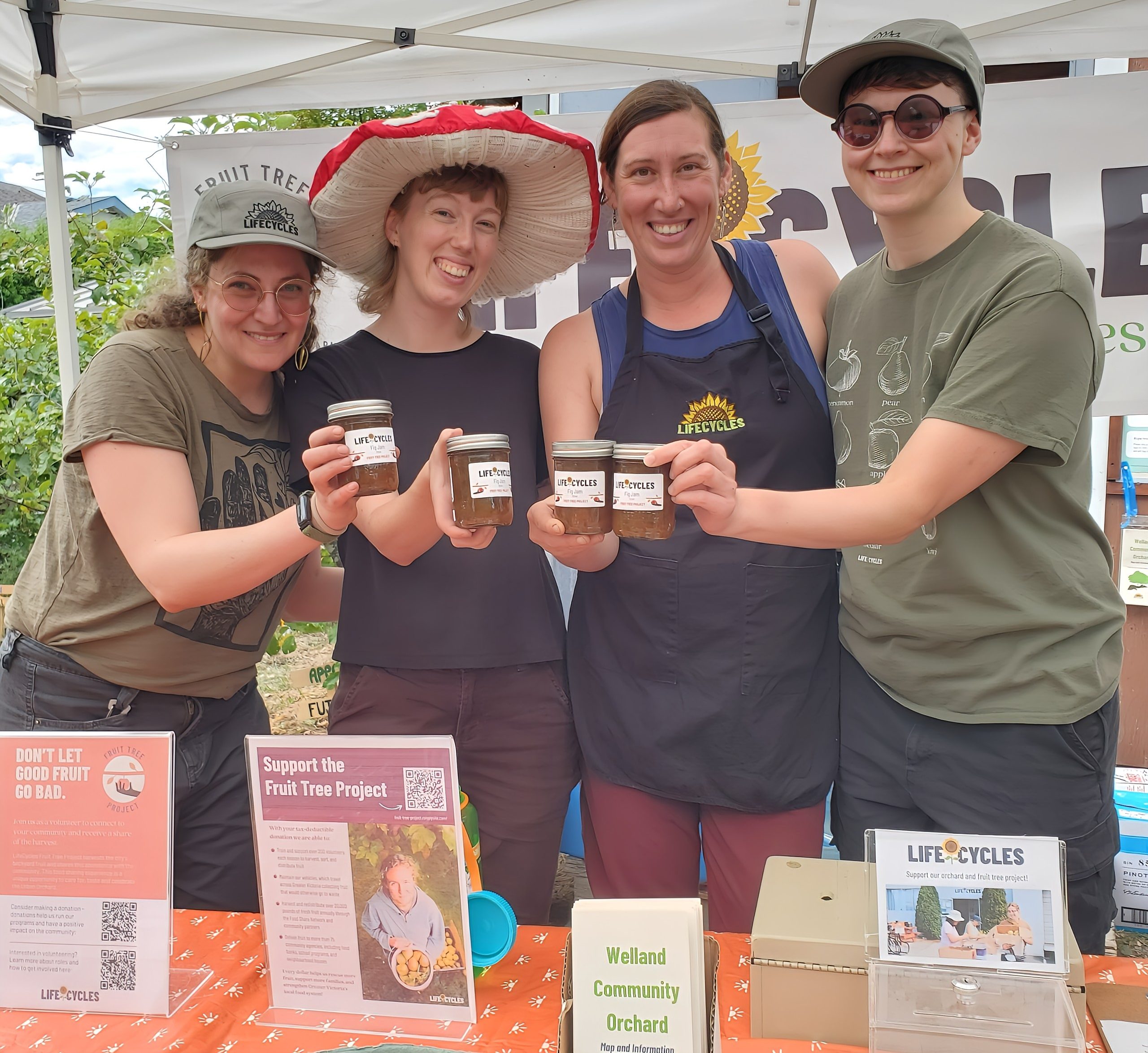 Four LifeCycles staff smiling and holding up jars of jam.
