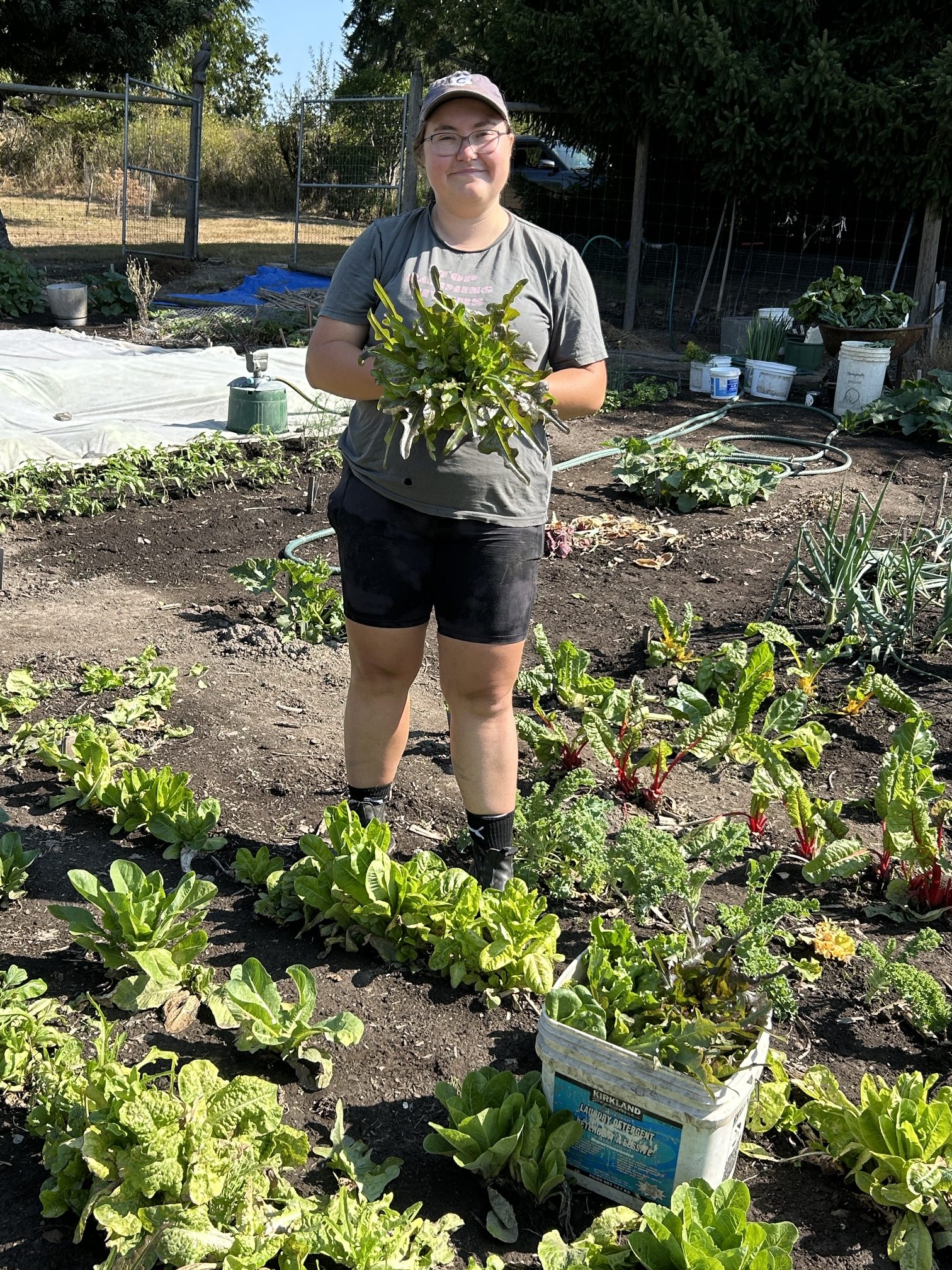A volunteer holding leafy greens gleaned from a local farm.